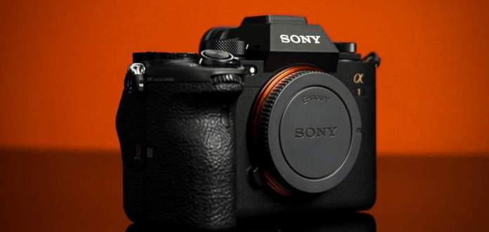 Product Shot of the Sony a1 taken on a black plexi with orange backdrop.